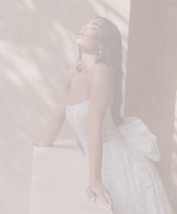 Model wearing a white dress on balcony. Background image